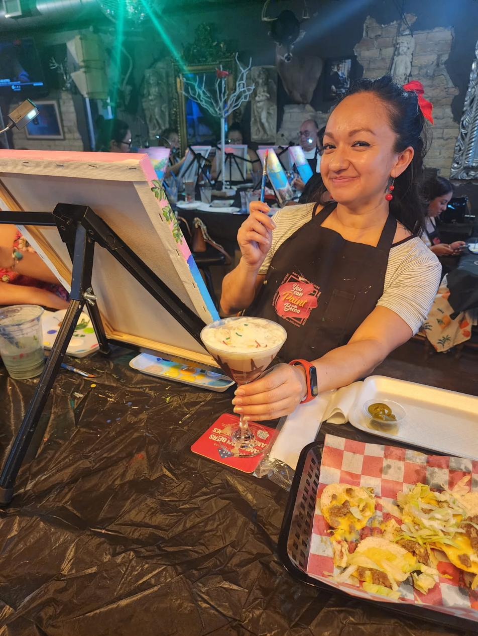 Becca painting at a bar event