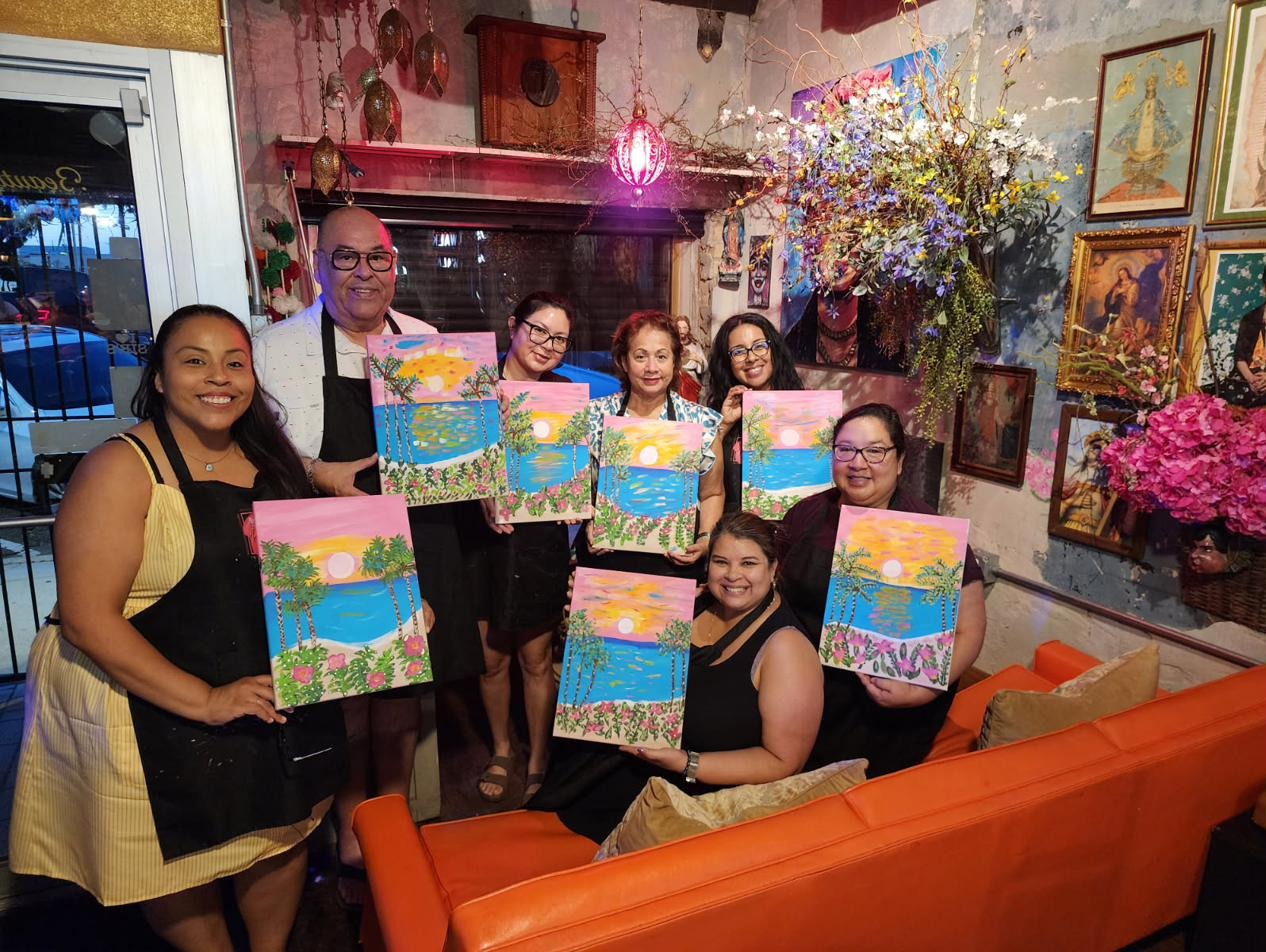 Guests holding palm tree sunset paintings